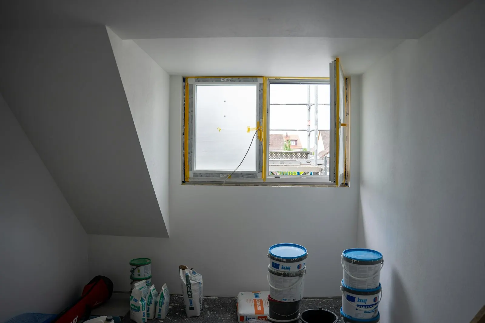 Raum mit Fenster und Baumaterial während der Renovierung in Deutschland